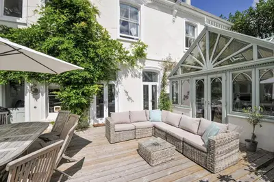 a patio with a couch and chairs on a wooden deck at Trenare in Truro