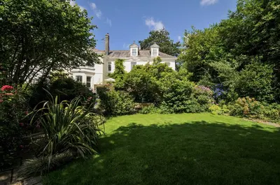 a large white house with a lawn in front of it at Trenare in Truro