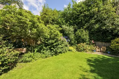 a garden with green grass and trees and bushes at Trenare in Truro