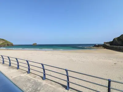 a blue railing on a beach with the ocean at Carn Brea in Redruth