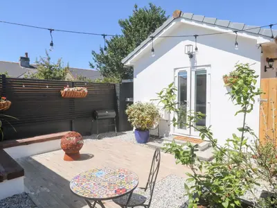 a patio with a table and chairs in a backyard at Carn Brea in Redruth