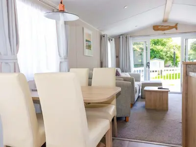 a dining room and living room with a table and chairs at Meadow 46 in Newquay