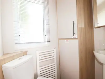 a bathroom with a toilet and a sink and a window at Meadow 46 in Newquay