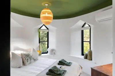 a bedroom with a white bed with a green ceiling at Castle by the Beach with Sea Views Portreath in Redruth