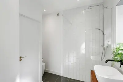 a white bathroom with a shower and a sink at Castle by the Beach with Sea Views Portreath in Redruth