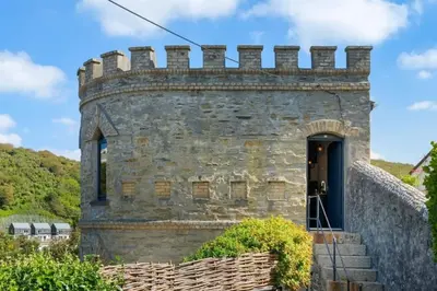 an old stone castle with a door and stairs at Castle by the Beach with Sea Views Portreath in Redruth