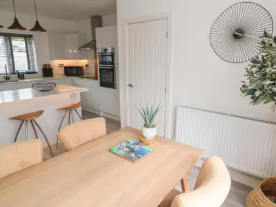 a kitchen with a wooden table and chairs in a kitchen at Miramar in St Ives