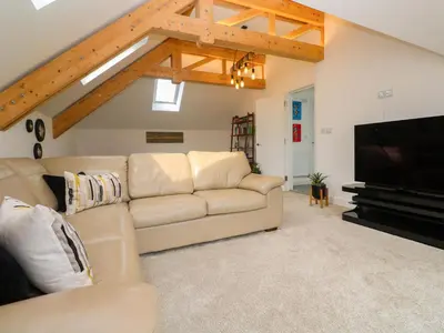 a living room with a couch and a flat screen tv at Miramar in St Ives
