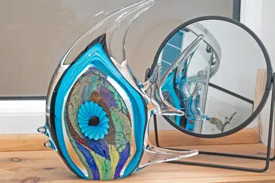 a glass vase on a table with a mirror at 7 Porth Valley Cottage's in Newquay