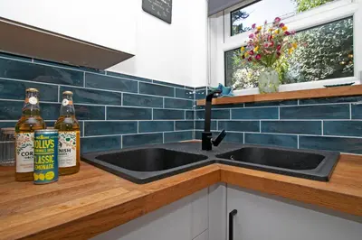 a kitchen with two bottles of beer next to a sink at 7 Porth Valley Cottage's in Newquay