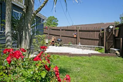 a backyard with a fence and a fire hydrant at 7 Porth Valley Cottage's in Newquay