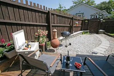 a backyard with a fence and a table and chairs at 7 Porth Valley Cottage's in Newquay