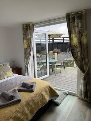 a bedroom with a bed and a patio with a table at Adorable 3 Bedroom House, Near Newquay 11 Miles in Saint Dennis