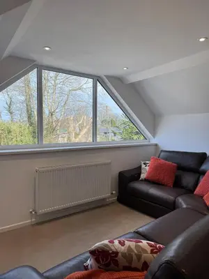 a living room with a couch and two windows at Adorable 3 Bedroom House, Near Newquay 11 Miles in Saint Dennis