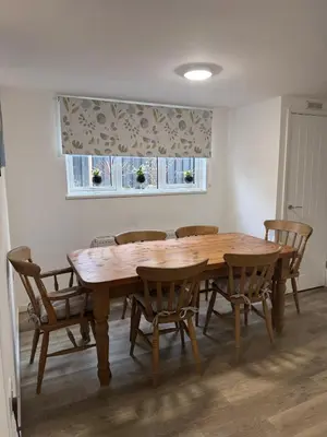a wooden dining room table with chairs and a window at Adorable 3 Bedroom House, Near Newquay 11 Miles in Saint Dennis