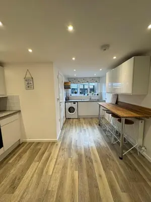 an empty kitchen with a table and a counter at Adorable 3 Bedroom House, Near Newquay 11 Miles in Saint Dennis