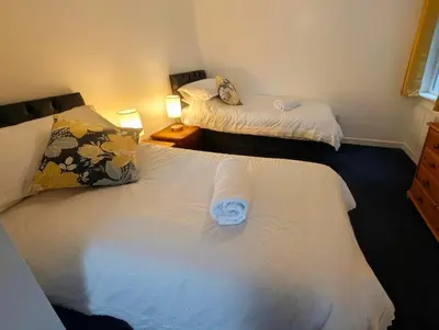 a bedroom with two beds with white sheets at Parkside Lodge Manor in Camelford