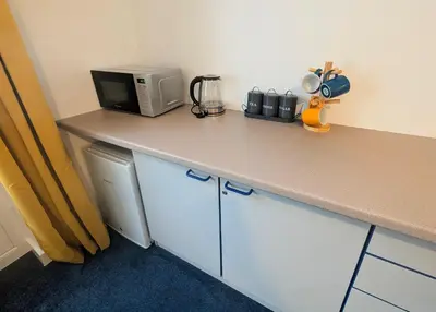 a kitchen with a counter with a microwave and a counter top at Parkside Lodge Manor in Camelford