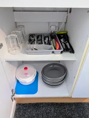 a shelf with plates and utensils in a refrigerator at Parkside Lodge Manor in Camelford