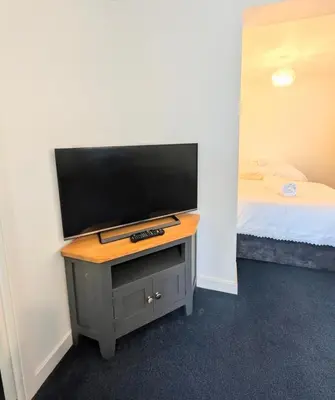 a tv on a table in a room with a bed at Parkside Lodge Manor in Camelford