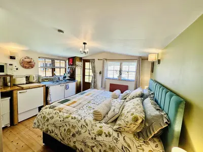 a bedroom with a large bed in a kitchen at Harvey's Lodge in Helston