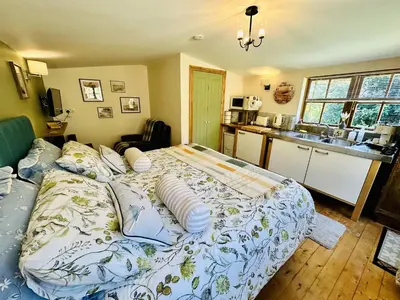 a bedroom with a large bed with pillows on it at Harvey's Lodge in Helston
