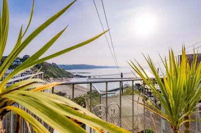 a view of the ocean from a balcony with plants at Cornwall Large Beach House Sea & Beach Views - 4 Bedrooms & 3 Bathrooms in Looe