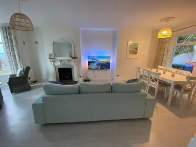 a living room with a couch and a dining room at Cornwall Large Beach House Sea & Beach Views - 4 Bedrooms & 3 Bathrooms in Looe