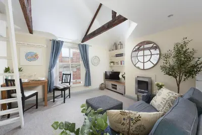 a living room with a blue couch and a desk at Bessie Ellens Cottage - 1 Pet Welcome - Central Location - Free WiFi in Fowey