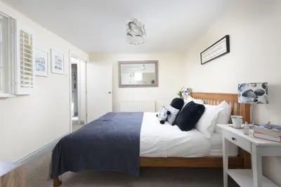 a bedroom with a large bed and a desk at Bessie Ellens Cottage - 1 Pet Welcome - Central Location - Free WiFi in Fowey