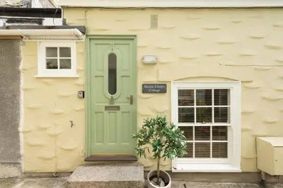 a green door on the side of a building at Bessie Ellens Cottage - 1 Pet Welcome - Central Location - Free WiFi in Fowey