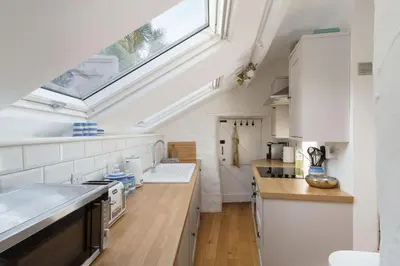a kitchen with white appliances and a skylight at Luxury Cornish Cottage & Modern Cabin with Garden, Central St Agnes in St. Agnes