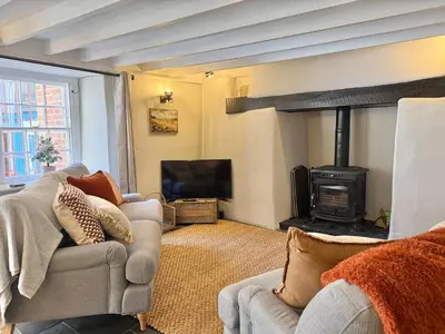 a living room with a couch and a fireplace at Luxury Cornish Cottage & Modern Cabin with Garden, Central St Agnes in St. Agnes