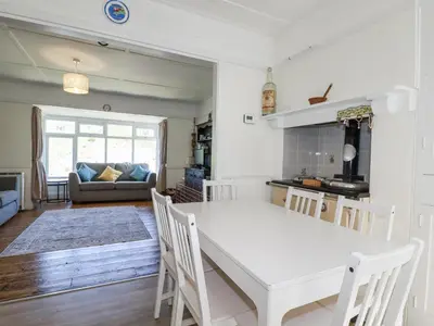 a kitchen and living room with a white table and chairs at Sea Ledge in Tintagel