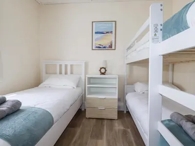 a bedroom with two beds and a bunk bed at Sea Ledge in Tintagel