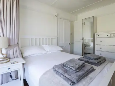 a bedroom with a white bed with towels on it at Sea Ledge in Tintagel