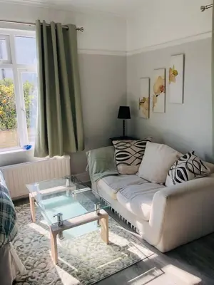 a living room with a couch and a glass table at The Studio in St Austell