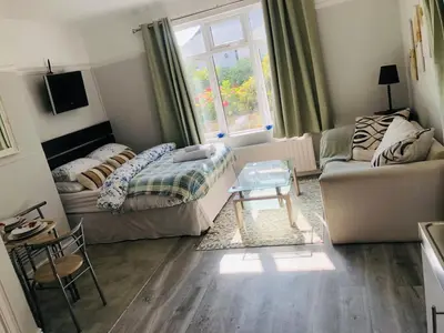 a living room with a couch and a table at The Studio in St Austell