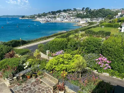 an aerial view of a garden with a bench and the ocean at Lantreath in Saint Mawes