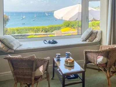 a room with a table and chairs and a large window at Lantreath in Saint Mawes