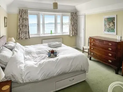a bedroom with a bed with a tray of food on it at Lantreath in Saint Mawes