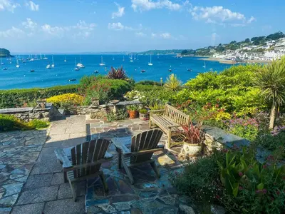 two chairs and a bench looking out at the water at Lantreath in Saint Mawes