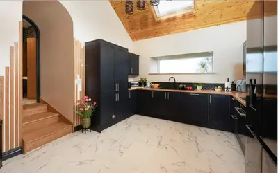 a kitchen with black cabinets and a staircase at La Casita in Breage