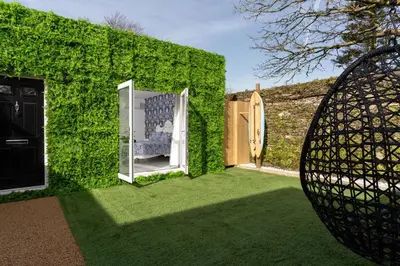 a green wall with a mirror in a yard at La Casita in Breage
