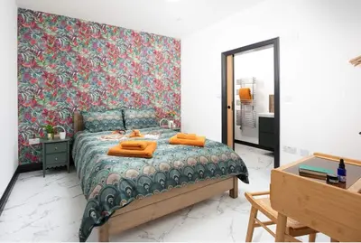 a bedroom with a bed with orange towels on it at La Casita in Breage