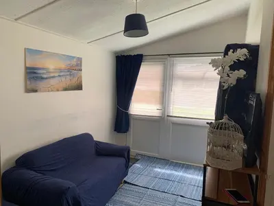 a living room with a blue couch and a window at Seabreeze Cottage in Padstow