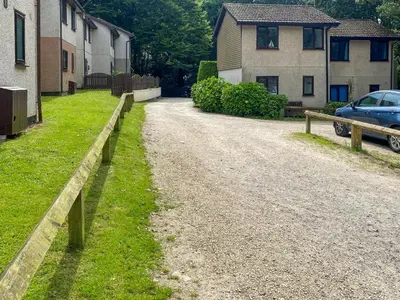 a dirt road next to a house and a car at Strawberry Hill in Hayle