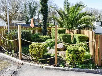 a garden with bushes and a wooden fence at Strawberry Hill in Hayle