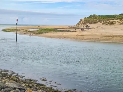 a beach with a sign in the middle of the water at Strawberry Hill in Hayle