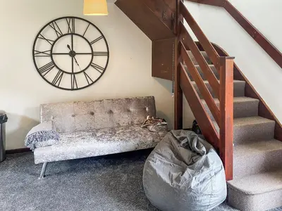 a room with a couch and a clock on the wall at Strawberry Hill in Hayle